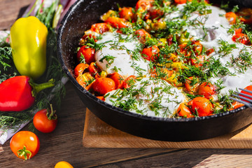 fried eggs with vegetables in a pan