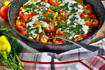 fried eggs with vegetables in a pan