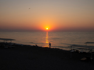 The sun rises from the horizon in the early morning on the sea