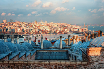 Beautiful view of the Golden Horn at sunset, Istanbul, Turkey. The roofs of the Suleymaniye Mosque in the rays of the setting sun against the blue sea in Istanbul