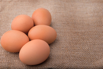 Fresh eggs on sackcloth. Copy the area for the text on the background, sackcloth, brown. 
