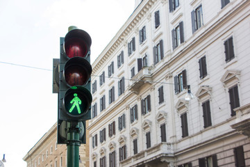 Green traffic light with colonial style building in background somewhere in Europe