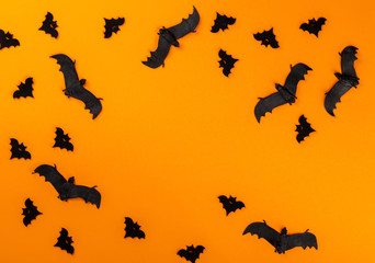 Halloween postcard. Тraditional festival of autumn. Decoration and party concept .Bats  on a orange background .Flat lay, top view, copy space