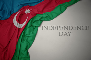 waving colorful national flag of azerbaijan on a gray background with text independence day. - obrazy, fototapety, plakaty