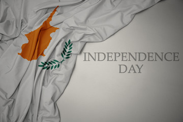 waving colorful national flag of cyprus on a gray background with text independence day.