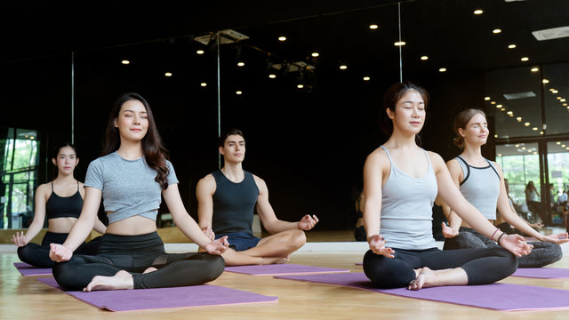 Multi-national People Group Practicing Yoga Skills In The Gym Is An Activity That Makes The Body Healthy. Have A Relaxed Mind And Helps The Muscles To Be Flexible Not Being An Office Syndrome.