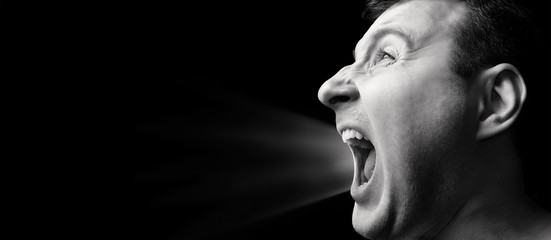 Concept of anger. Portrait of a screaming man on isolated background with free space. Black and...