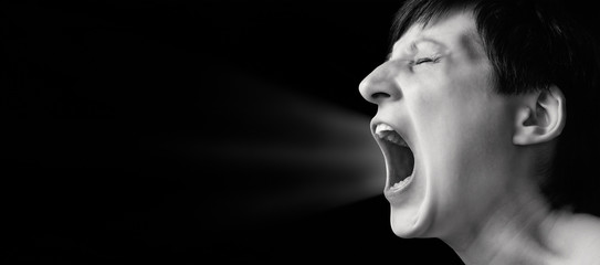 Concept of anger. Portrait of a screaming woman on isolated background with free space. Black and...