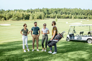 Young and elegant friends walking with golf equipment, hanging out together on the beautiful course...