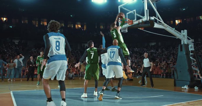 Basketball players on big professional arena during the game. Tense moment of the game. Celebration