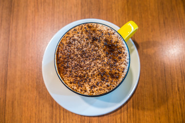 Cup of coffee on wooden table, top view. Coffee cup top view on wooden table background