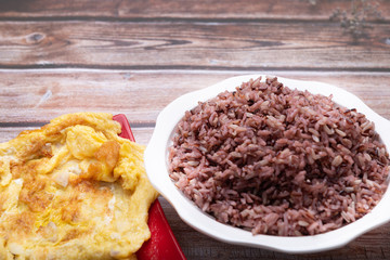 Riceberry 1 bowl of white and omelette in a red dish On the old wooden floor, copy the area for the text