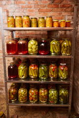 shelves with homemade pickled vegetables and stewed fruit. Vertical shot.
