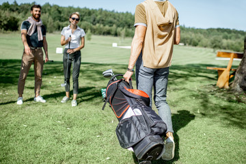 Obraz premium Young elegant friends meeting on the golf course before the play, having fun together on a sunny day