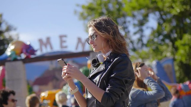 Young woman buys electronic tickets for attractions in park