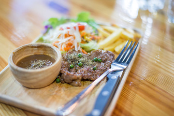 beef steak on wooden dish with vegetable salad and french fried