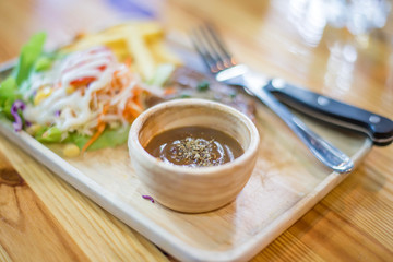 beef steak on wooden dish with vegetable salad and french fried