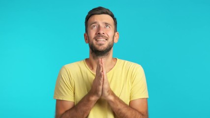 Young man making a wish ask for good luck with crossed fingers and pray