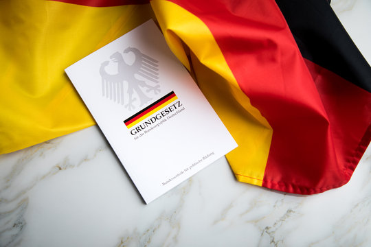 Das Grundgesetz Buch der Bundesrepublik Deutschland auf Flagge und Marmor Hintergrund
