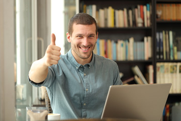 Happy adult man with laptop with thumbs up
