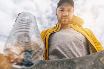 man throw plastic bottle in to garbage