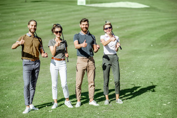 Portrait of a young group of friends as a golf team players, showing OK sign while standing...
