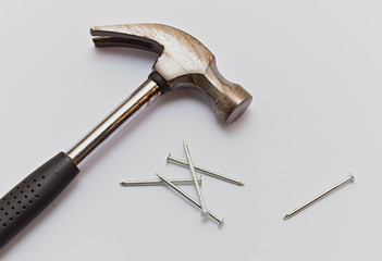 Hammer and construction nails on isolated white background, close-up.