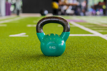 Naklejka na ściany i meble Kettlebell on artificial grass in the gym. Healthy exercise concepts