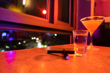 Cocktail and cigarette in the bar at the night