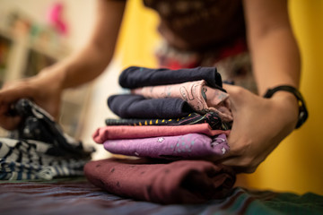 Shallow depth of field image with the hands of a mother rearranging her little daughter clothes