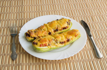 Zucchini boat with chicken, beans and vegetables under cheese