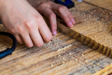 Mão feminina trabalhando na madeira