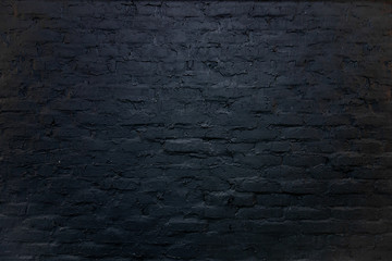 Black brick wall background. Backdrop of design interior in grunge style. Rough surface with textured coating painted in dark color