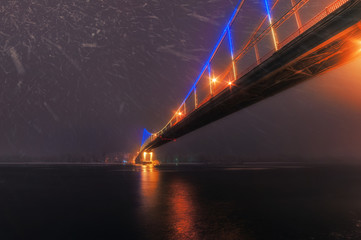 Fototapeta na wymiar night city view, luminous bridge. winter cityscape