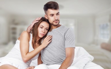 Fototapeta premium Niezadowolona piękna młoda kobieta w łóżku ze smutnym wyrazem twarzy, problemami seksualnymi w długim związku lub małżeństwie podczas snu mężczyzny. Nasycenie lub sytość między kaukaską parą, brak zainteresowania