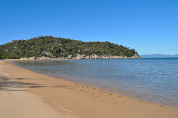 Beach scene at Picnic Bay on Magnetic Island, Queensland, Australia, looking to the headland and beyond to the mainland near Townsville.