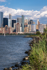 Lower Manhattan skyline with boat and ferry on Hudson river view from Liberty State Park in late summer