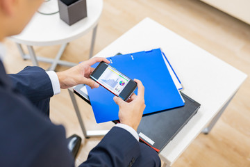ビジネスイメージ　スマートフォン　グラフ　画面を見る　デジタル化