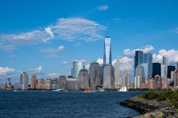Fototapeta premium Lower Manhattan skyline with boat and ferry on Hudson river view from Liberty State Park in late summer