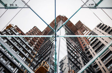 Glass construction on the background of building under construction with concrete and glass.