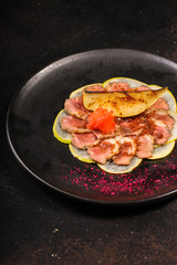 duck meat carpaccio with pear flambe (tasty snack, aperitif) menu concept. food background. copy space. Top view