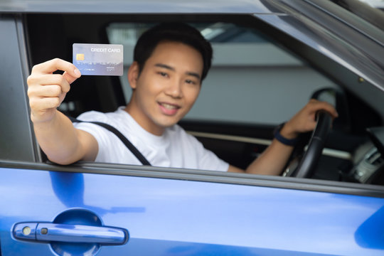 Happy Young Asian Man Holding Payment Card Or Credit Card And Used To Pay For Gasoline, Diesel, And Other Fuels At Gas Stations, Driver With Fleet Cards For Refueling Car