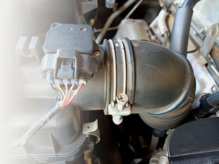 the big  black air tube connect ed with sensor and electric wire in engine room of a car