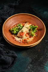 fish baked with vegetables (main course, white fish seafood, broccoli, carrots and others) menu concept. food background. copy space. Top view