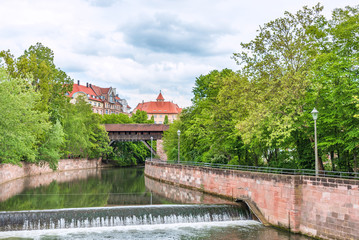 Fototapeta na wymiar Canal in old Nuremberg surrounded by green trees