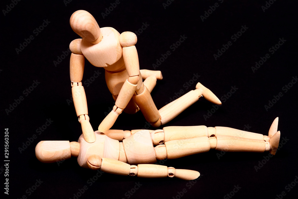 Wall mural Conceptual image of wooden manikins administering CPR resuscitation