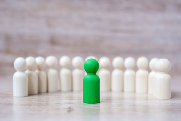 Green leader businessman with crowd of wooden men. leadership, business, team, teamwork and Human resource management concept