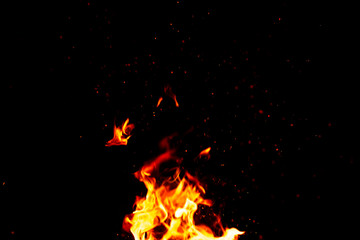 Fototapeta na wymiar fire and sparks, from a campfire on a dark night background, front and background blurred