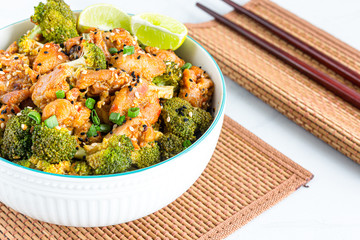 Broccoli and Chicken Stir Fry in a Bowl with Chopsticks, White Background Close Up Photo.