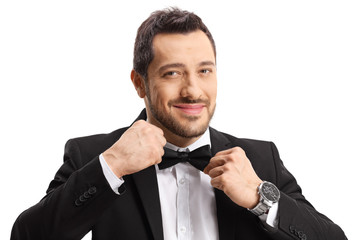 Handsome man in a suit making his bow-tie